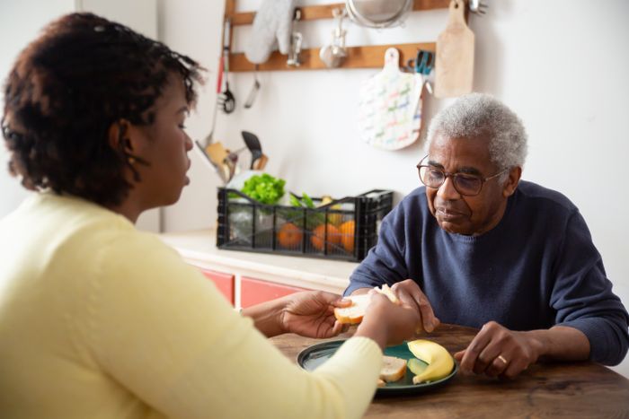 A daughter sharing a meal with her father at the kitchen table