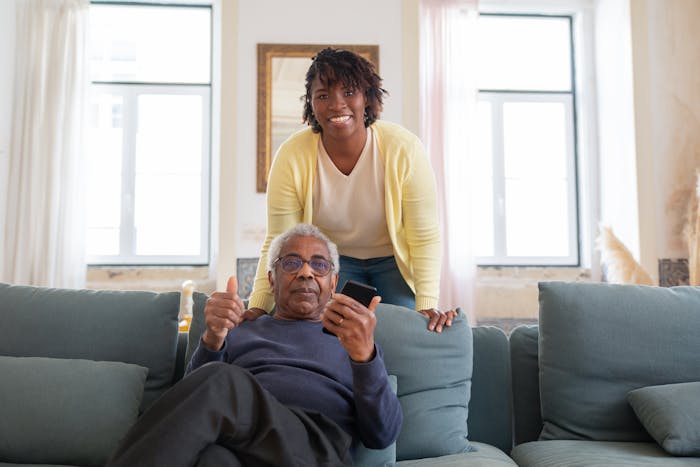 A father smiling beside his daughter at home