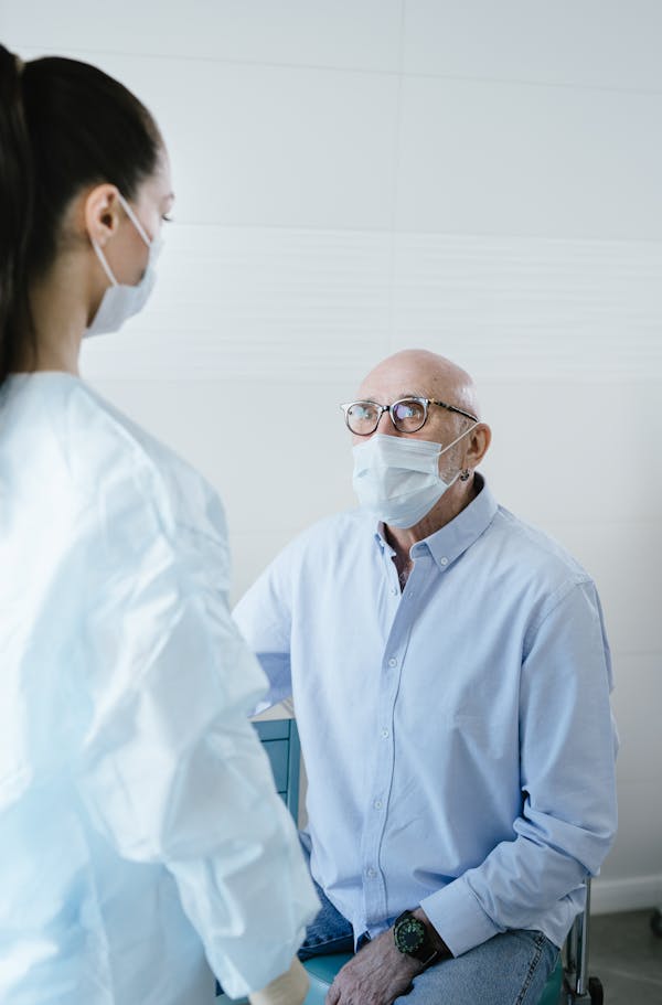 An older patient speaks with a nurse at a clinic appointment