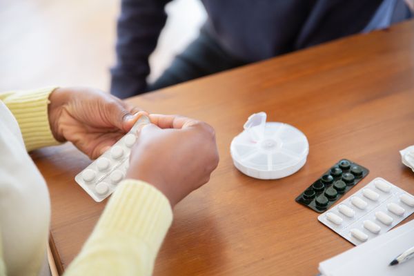 A caregiver counts out the week's pills into an organizer